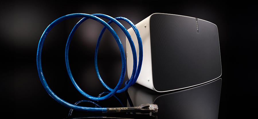 Blue Heaven Ethernet cable coiled next to a modern white streaming speaker