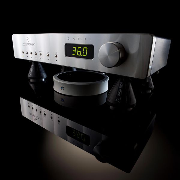 Silver audio preamp supported by Nordost Sort Kones with reflections on glossy black surface
