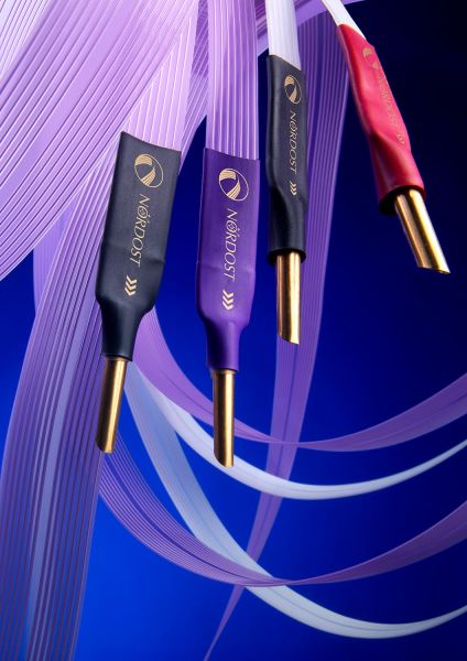 Close-up of four Nordost banana plugs with purple ribbon speaker cables against a vibrant blue background