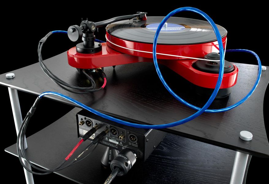 Blue Nordost tonearm cable connected to a red turntable on a black hi-fi rack